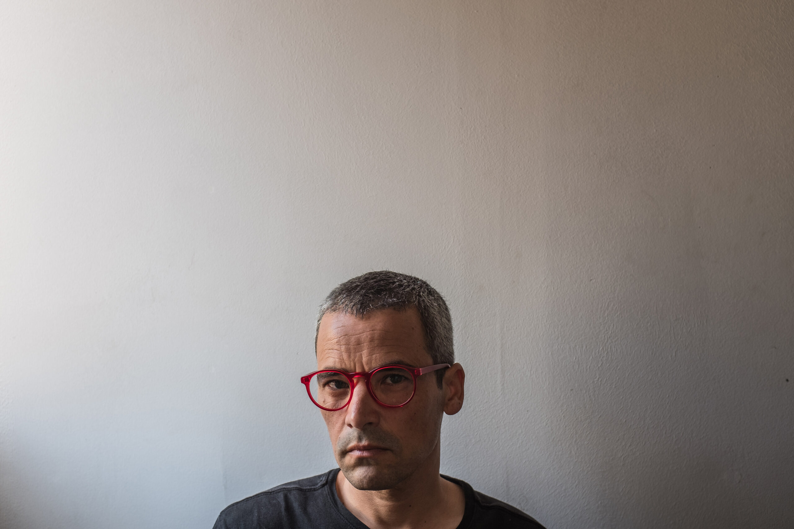 Retrato de hombre con gafas sobre fondo gris claro